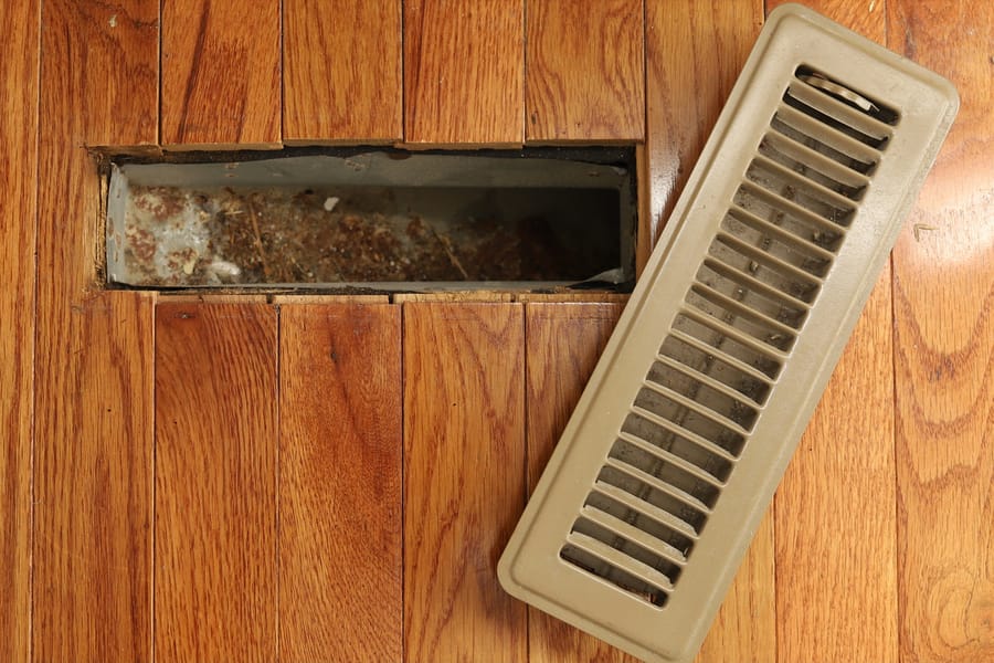 Dirty open vent in floor.