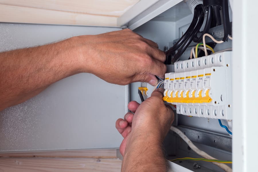 Electrician repairing an open distributor panel.