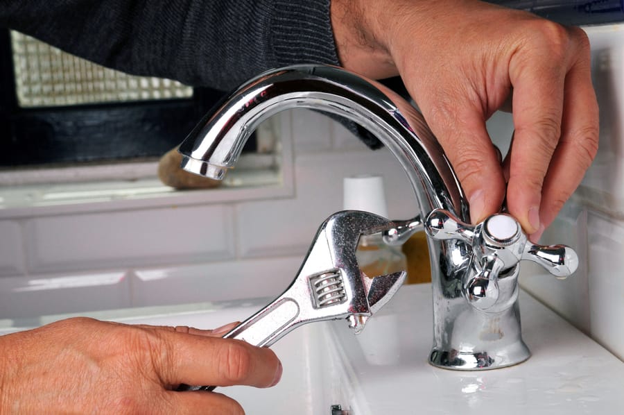 A plumber repairing a faucet.