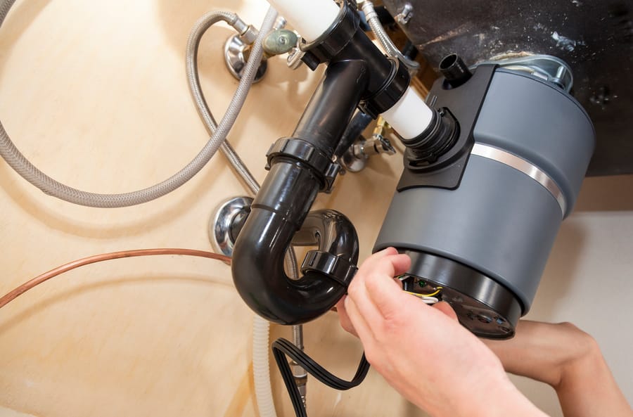 Plumber repairing garbage disposal.