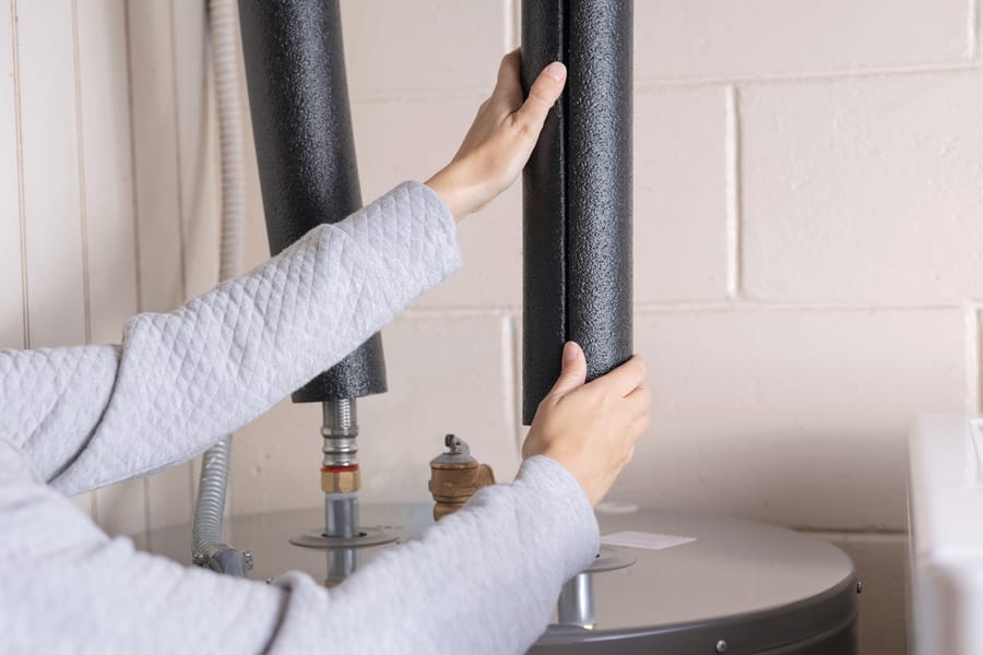 Insulation being wrapped around water heater.