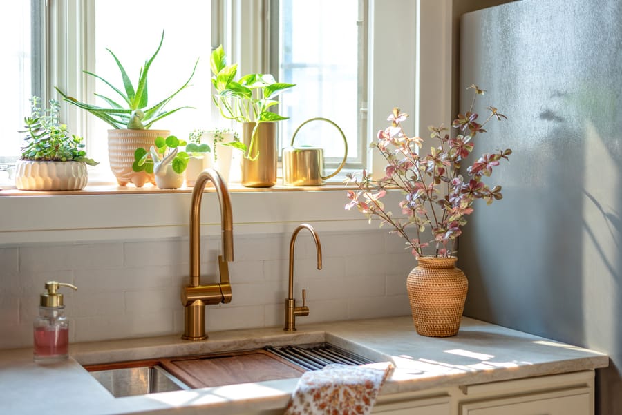 A kitchen sink with copper faucet fixtures.