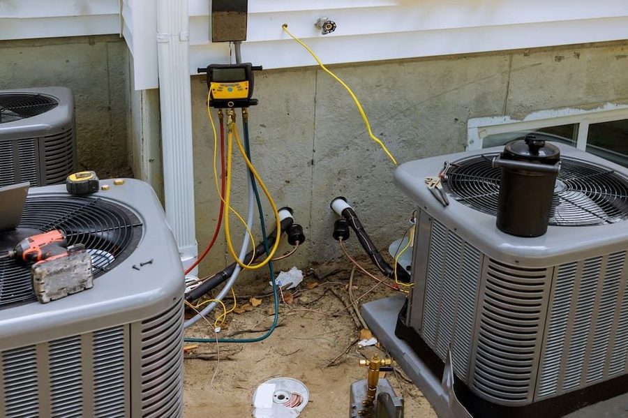 Air conditioning units being tested. Maintenance being performed on two outdoor AC units